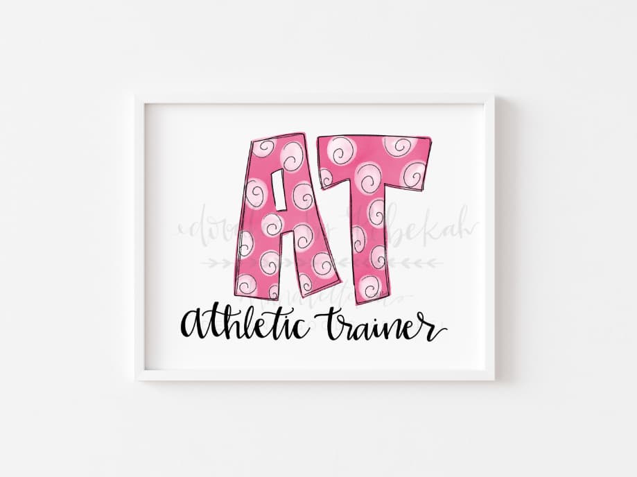 An 8x10 print of the phrase 'Athletic Trainer' with a stylized 'AT' in pink, on a white background with a pink border.