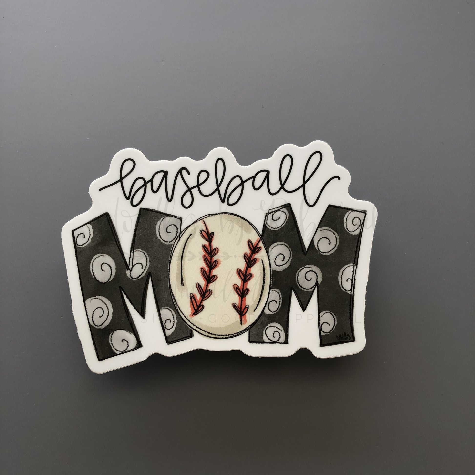 A sticker with the text 'Baseball MOM' designed with a baseball and decorative swirls.