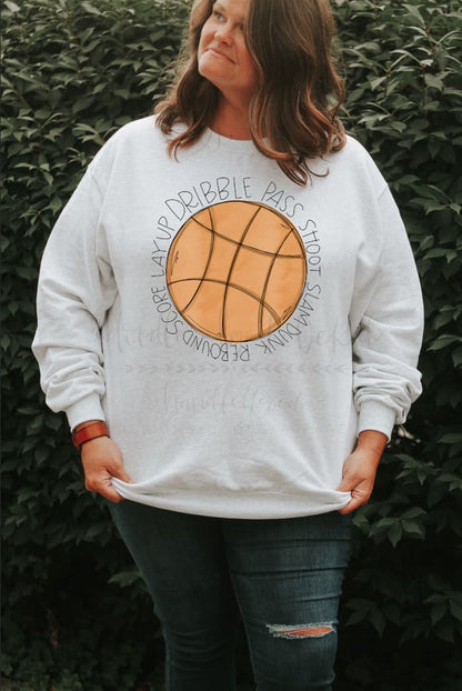 Woman wearing a sweatshirt with a basketball graphic on it. 