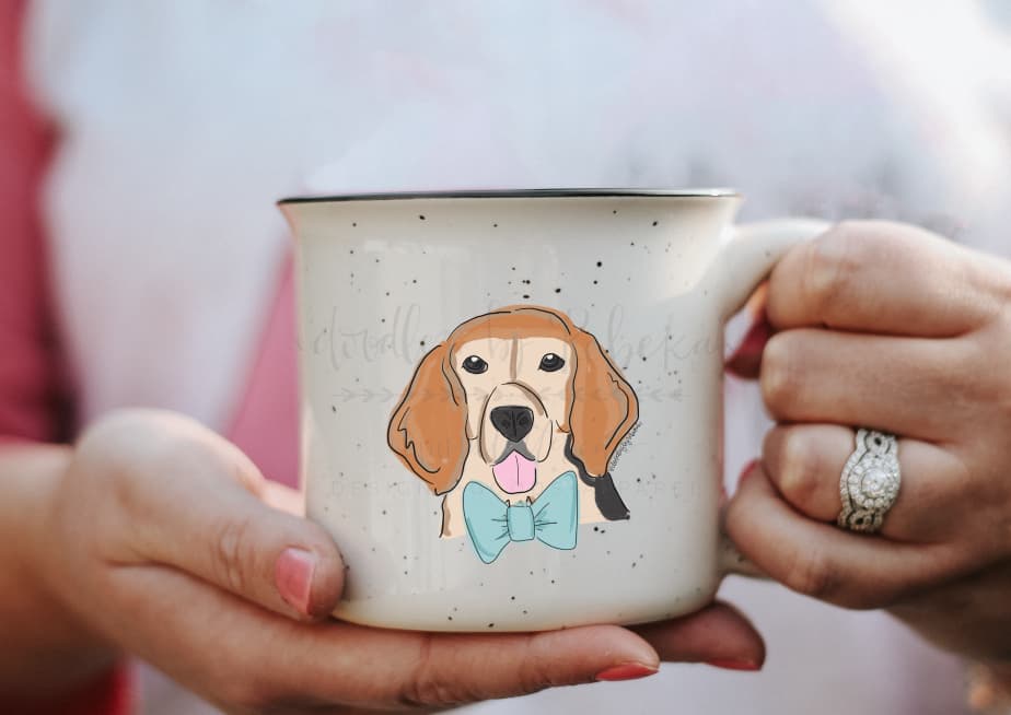 Person holding a coffee mug with a graphic of a male beagle wearing a blue bowtie