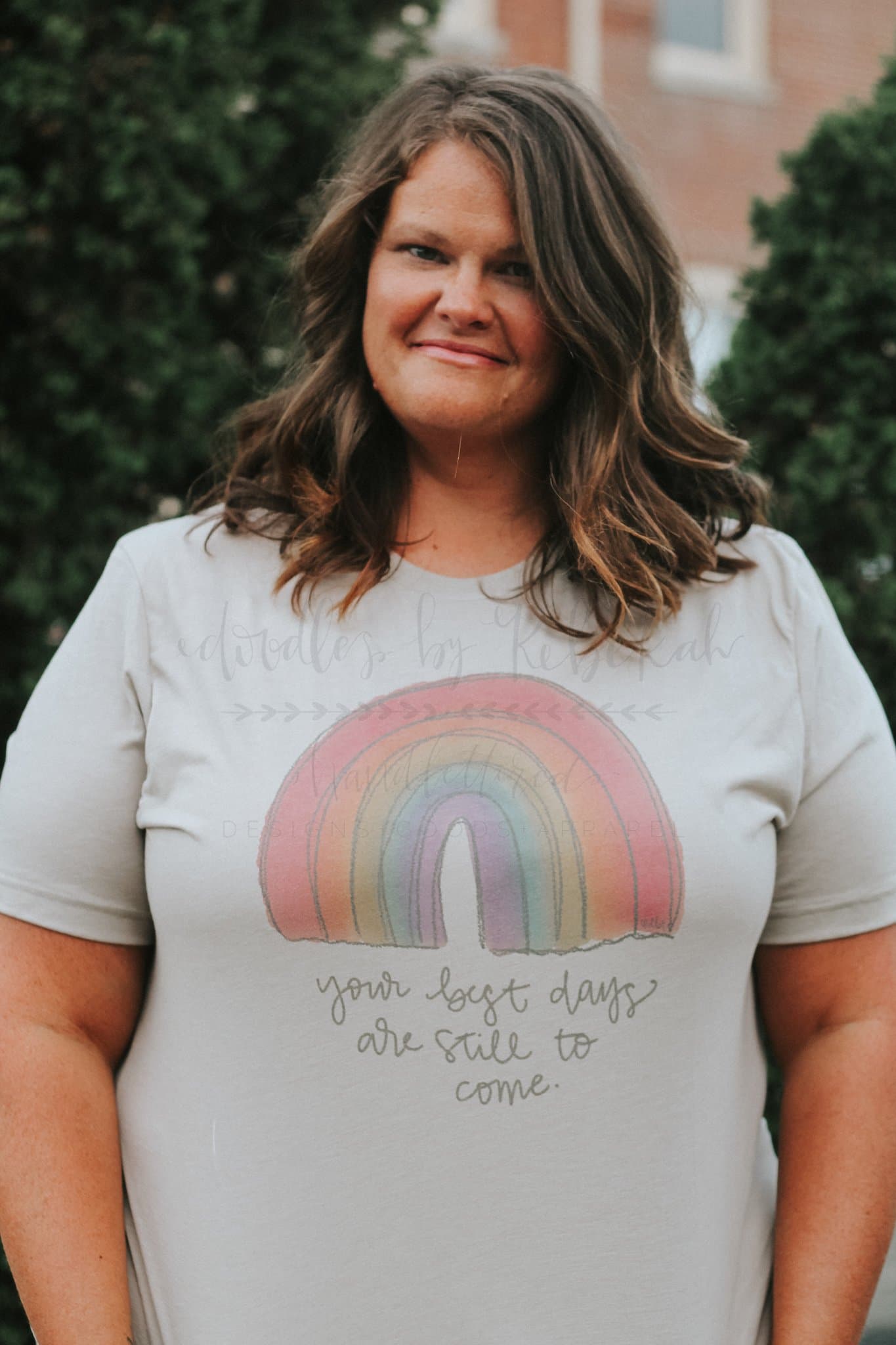 Women's graphic t-shirt with a rainbow design and motivational "your best days are still to come" message in a soft grey cotton blend.