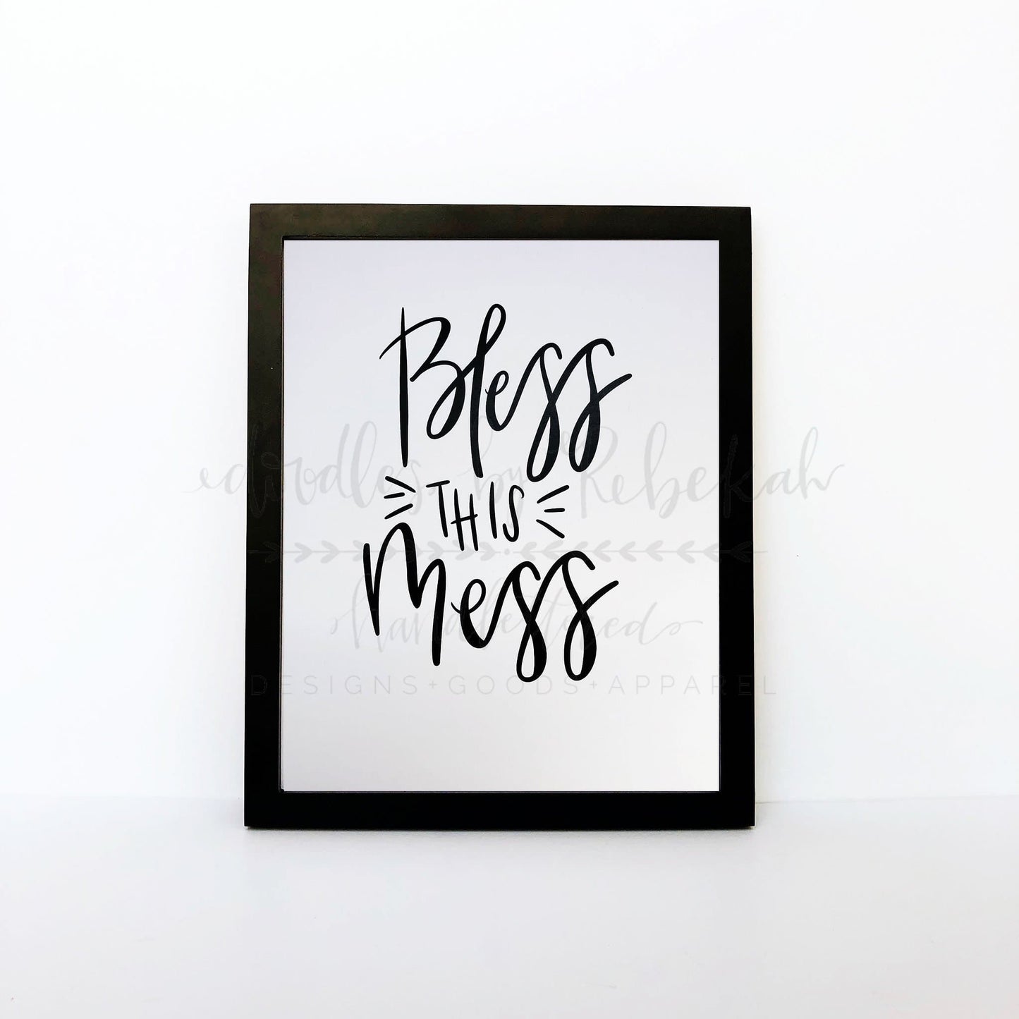 An 8x10 framable print with the phrase 'Bless This Mess' in a cursive handwritten-style font, predominantly in black ink on a white background.