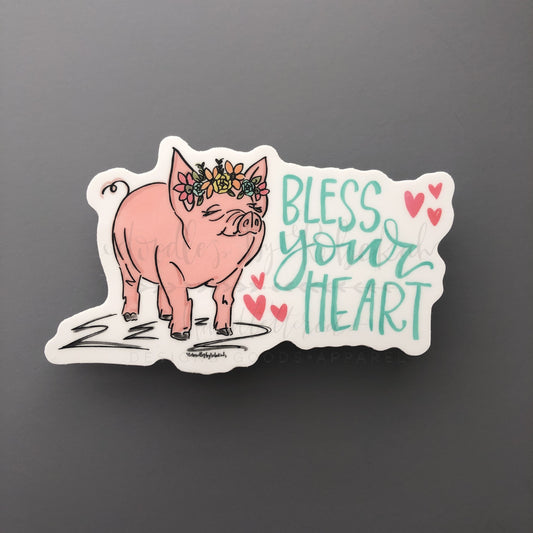 A sticker with an illustration of a pig and the phrase 'Bless your heart' surrounded by hearts.