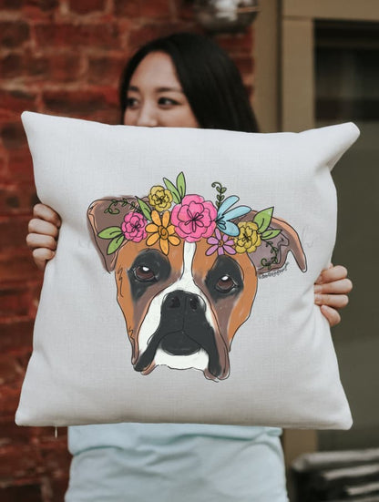 A square pillow with a whimsical drawing of a boxer dog with a flower crown