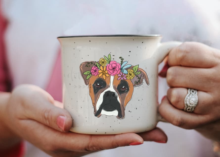 a speckled coffee mug with a whimsical drawing of a boxer dog with a flower crown