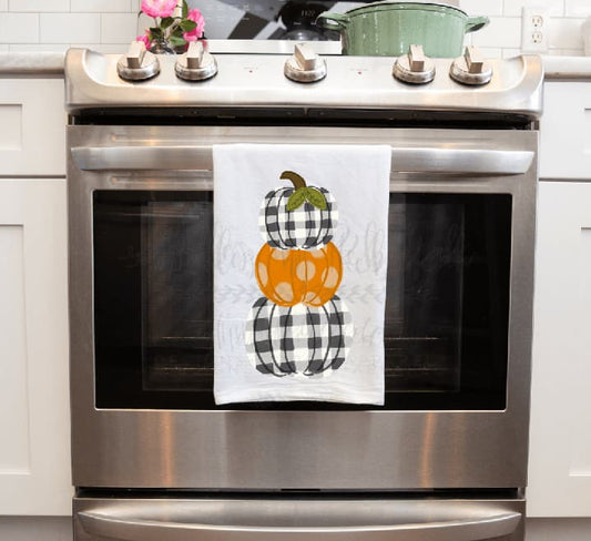 Buffalo Plaid and Polka Dot Pumpkin Tea Towel hanging on a stove