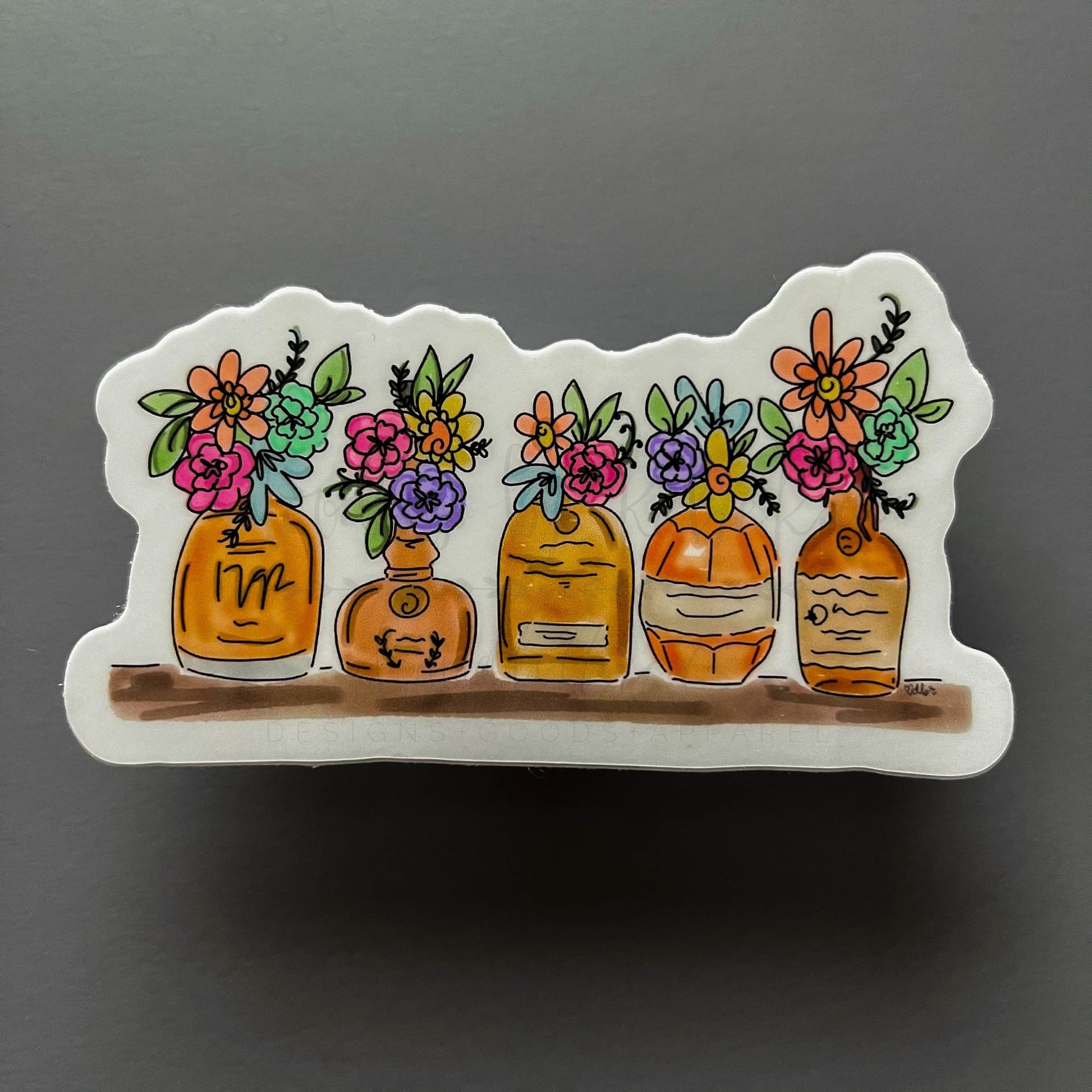 Sticker with bourbon bottles on a shelf holding wild flowers
