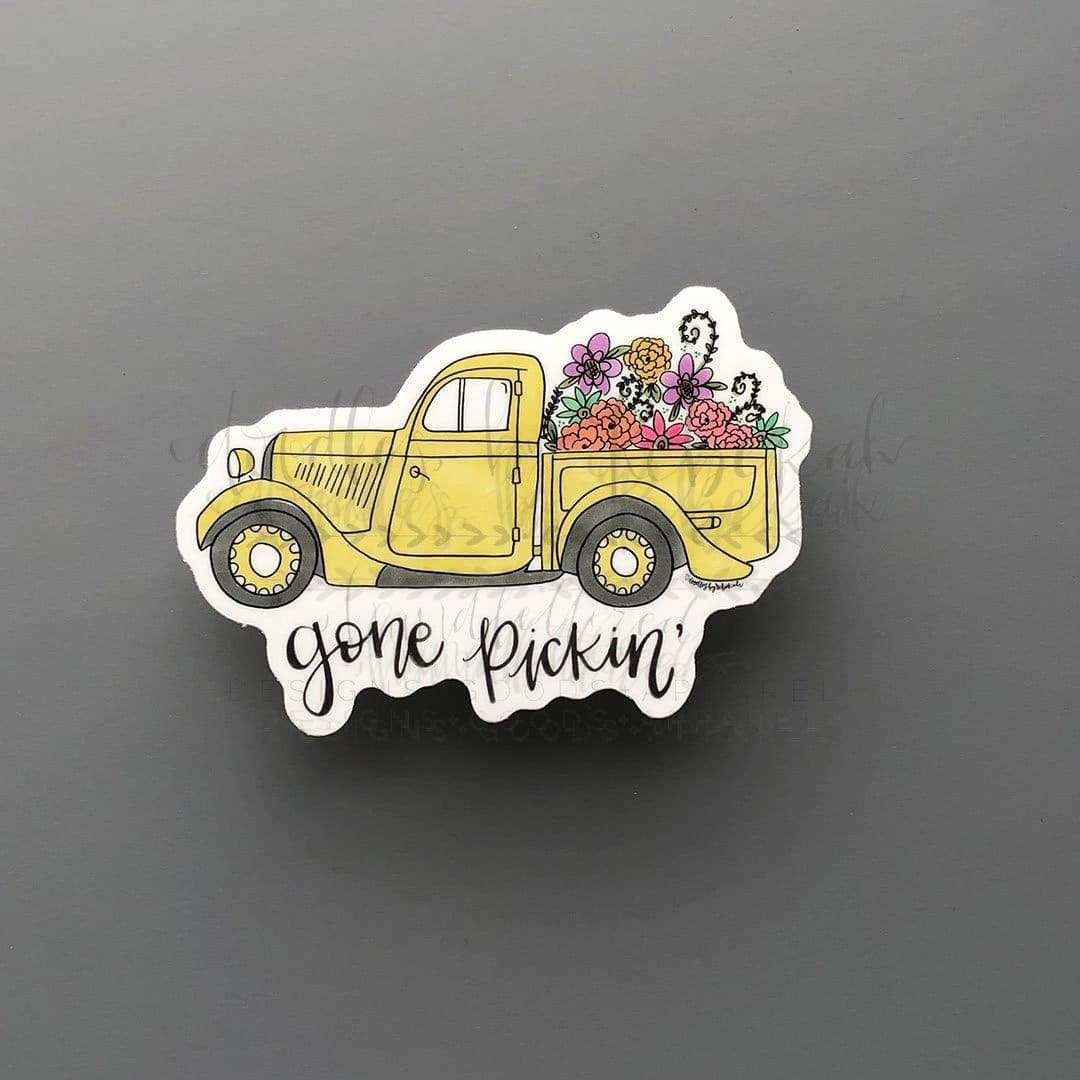 A sticker portraying a yellow truck with flowers in the back that says "gone pickin'"
