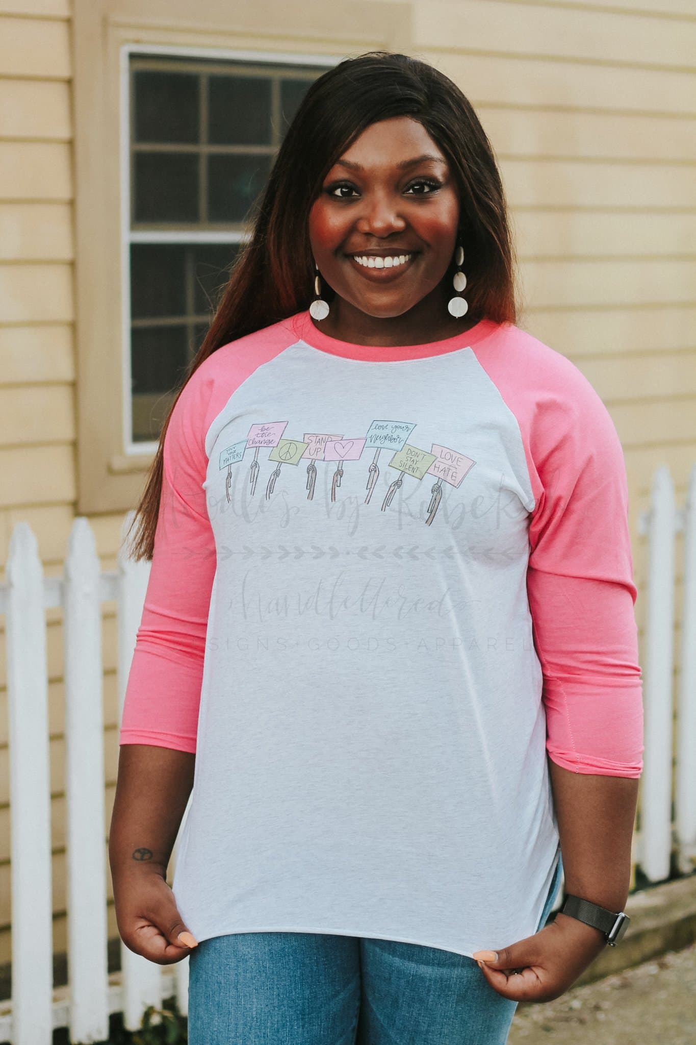a woman wearing a pink and whit raglan that says "Your Voice Matters'